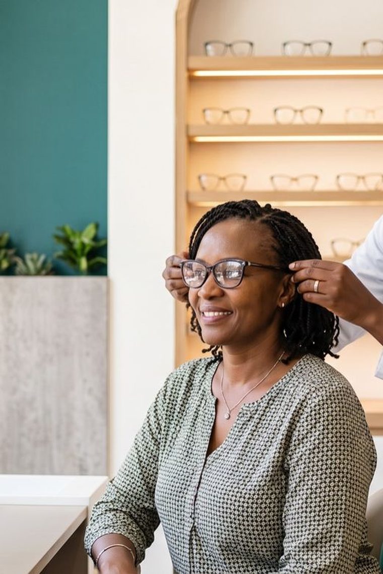 Optometrist at Focus Diagnostics fitting glasses for a patient during an eye test